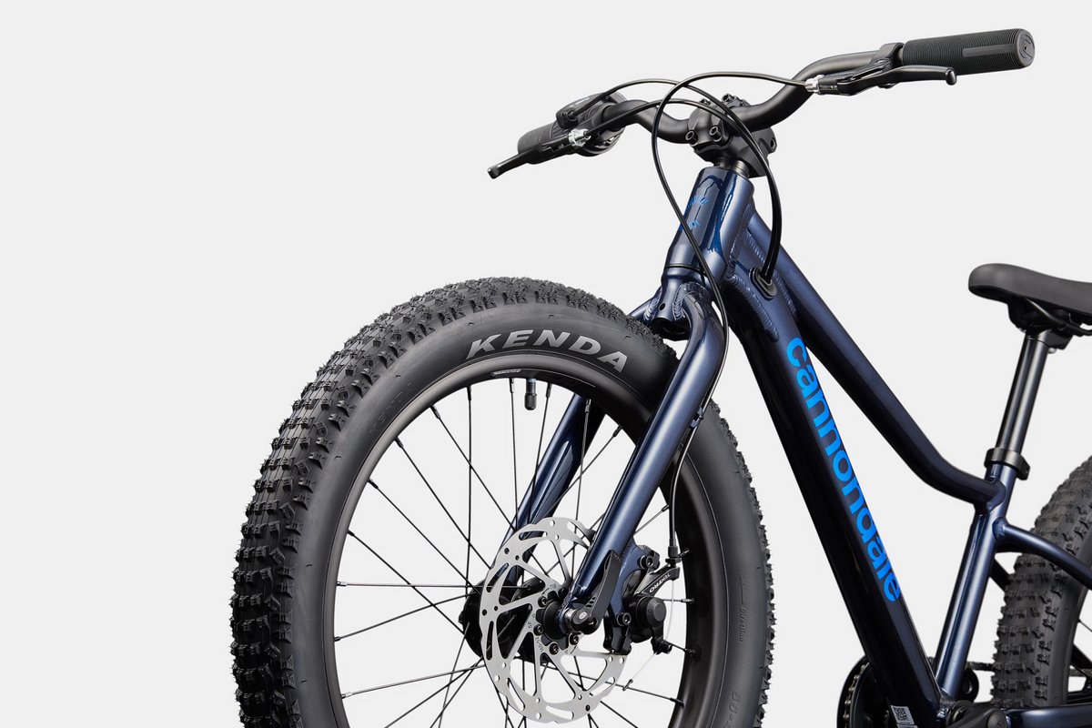 Blue kids mountain bike with the brand name 'Cannondale' printed in blue down the down tube with a white background