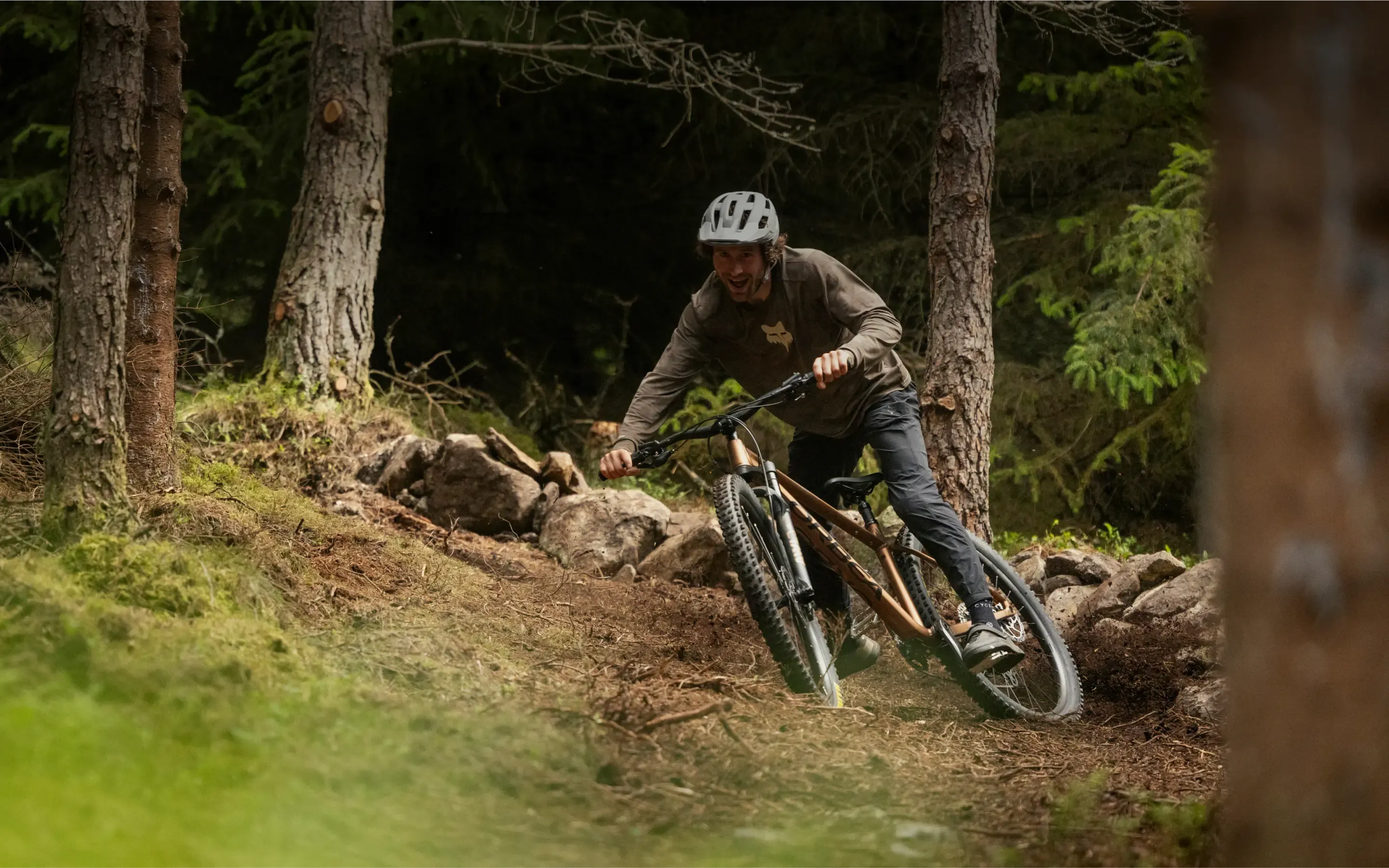 Person riding a mountain bike on a trail through a forest