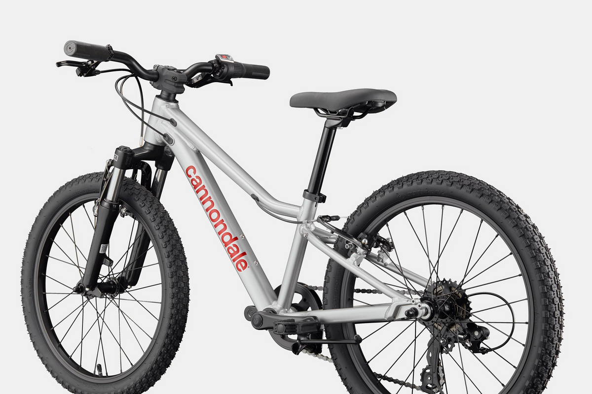 A silver Cannondale kids mountain bike on a white background