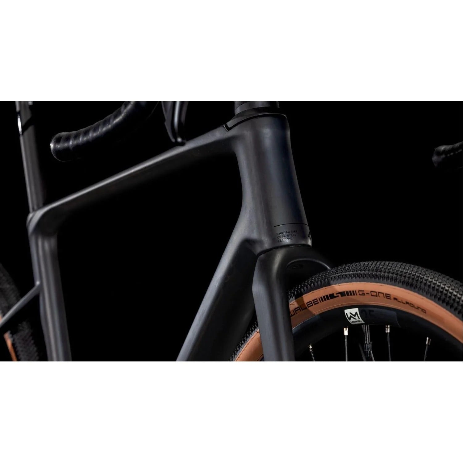 Close-up of a gravel bike frame and tyre on a black background