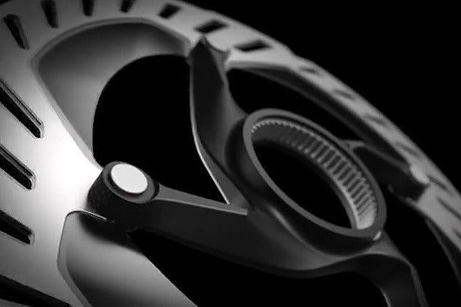 Close up of a bicycle disc rotor on a black background