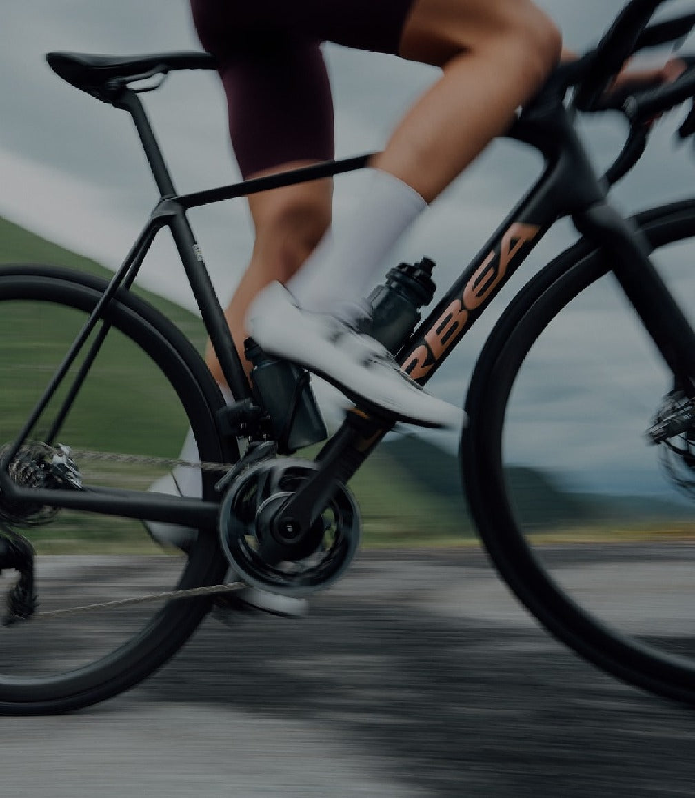 Cyclist riding a black Orbea road bike  on a blurred background