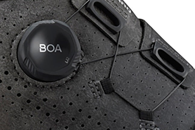 Close-up of a BOA system on a black  mountain bike shoe with detailed texture.
