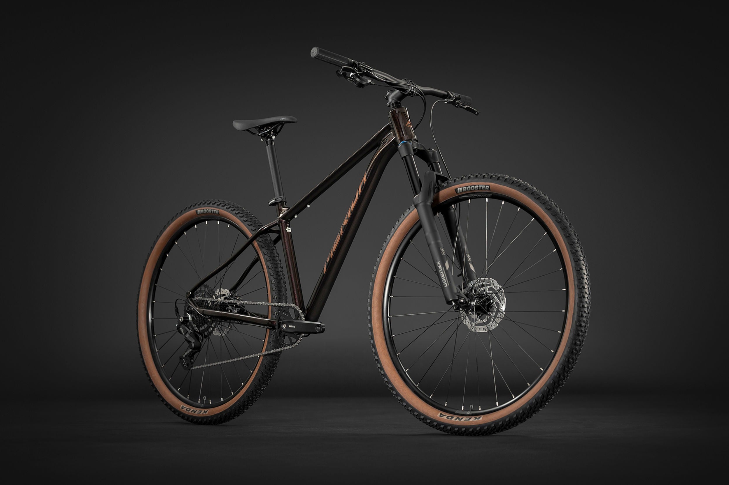 Black Merida mountain bike with brown tyres on a black background