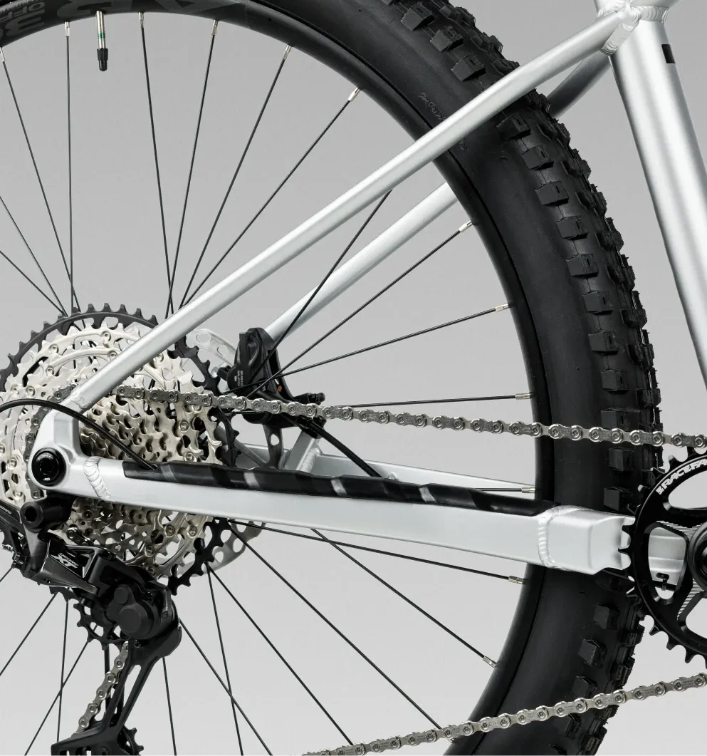 Close-up of a bicycle chain and gear system on a light gray background