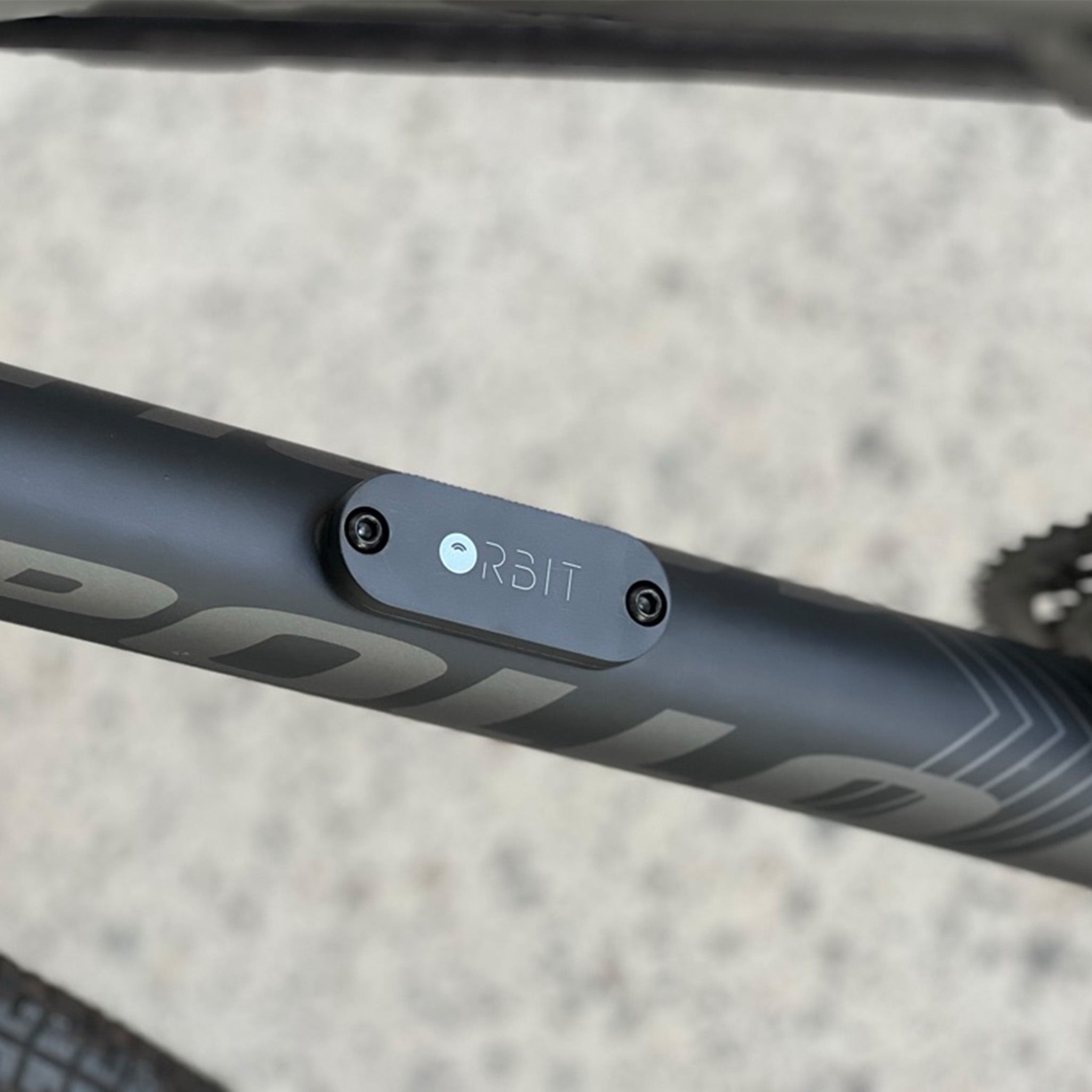 An Orbit tracking device mounted to a bicycle frame with a blurred background