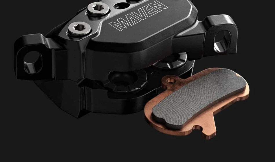 Maven Disc brake caliper with disc about to be slotted in on a dark grey background