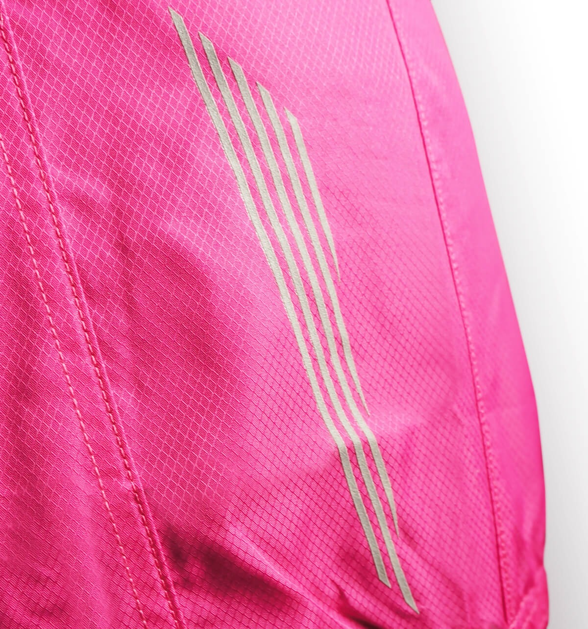 Close-up of a pink cycling vest with three white stripes on a white background