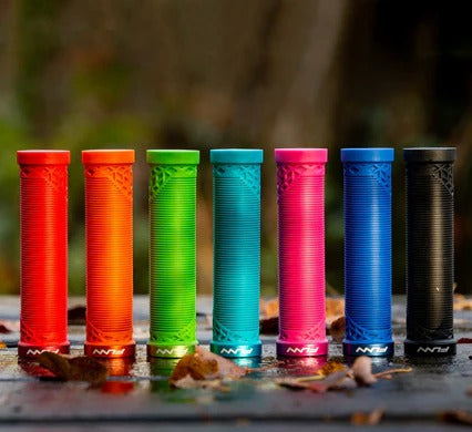 Six FUNN brand handlebar grips in vibrant colors (red, orange, green, teal, pink, blue) and one black grip, lined up on a wet surface with blurred autumn leaves and a forest background.