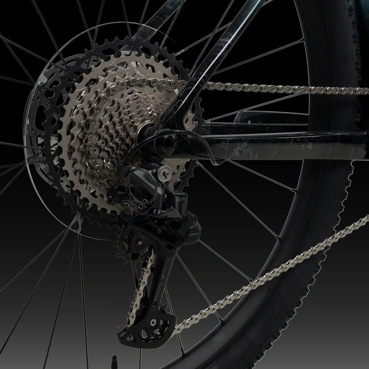 A close up of a bicycle rear drivetrain on a dark background