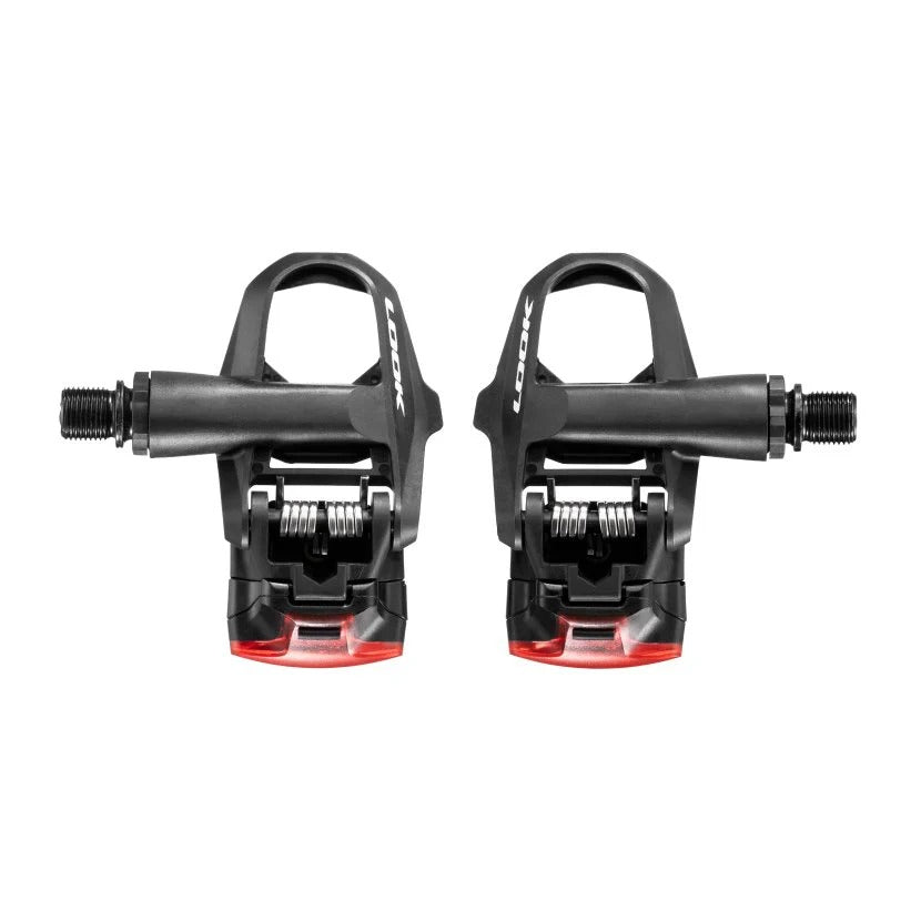 Pair of black road bike pedals with integrated rear lights on a white background