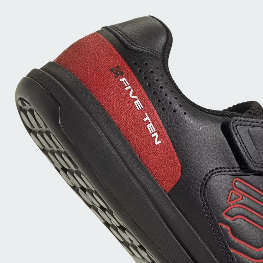 Black and red Five Ten mountain bike shoe with a close-up of the sole on a white background
