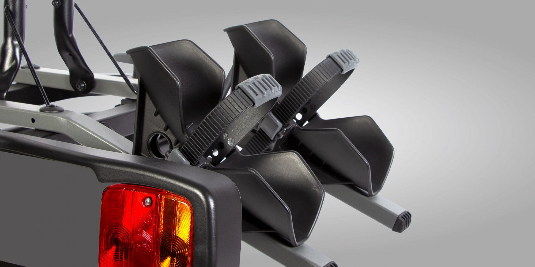 Close up of the wheel holder with straps on a bike rack against a gray background