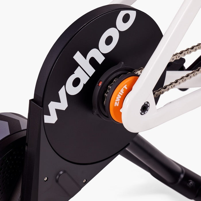 Close-up of a Zwift Click + Cog Upgrade Pack on a Wahoo fitness device on a stationary bike with 'Zwift' branding.