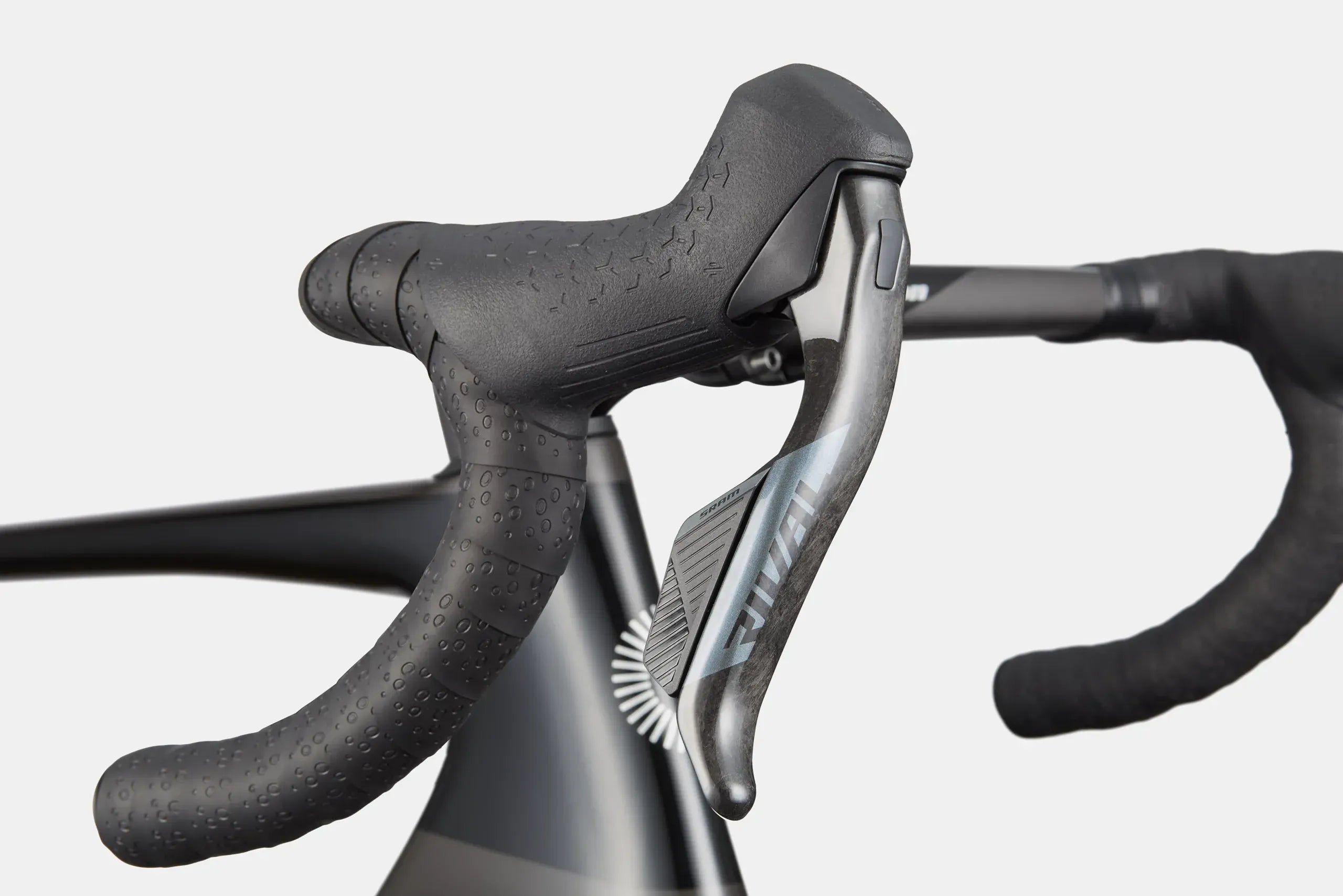 Close-up of road bike handlebar with SRAM Rival gear and brake on a white background
