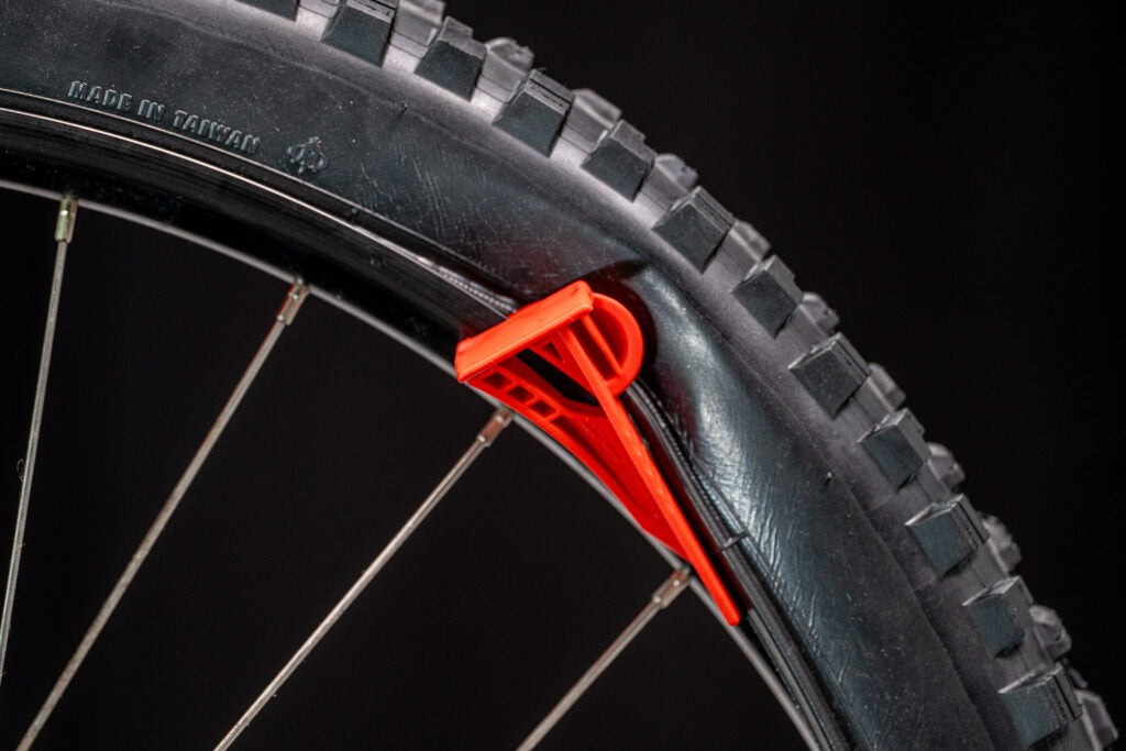 Close-up of a bicycle tre with a red tyre lever tool on a black background
