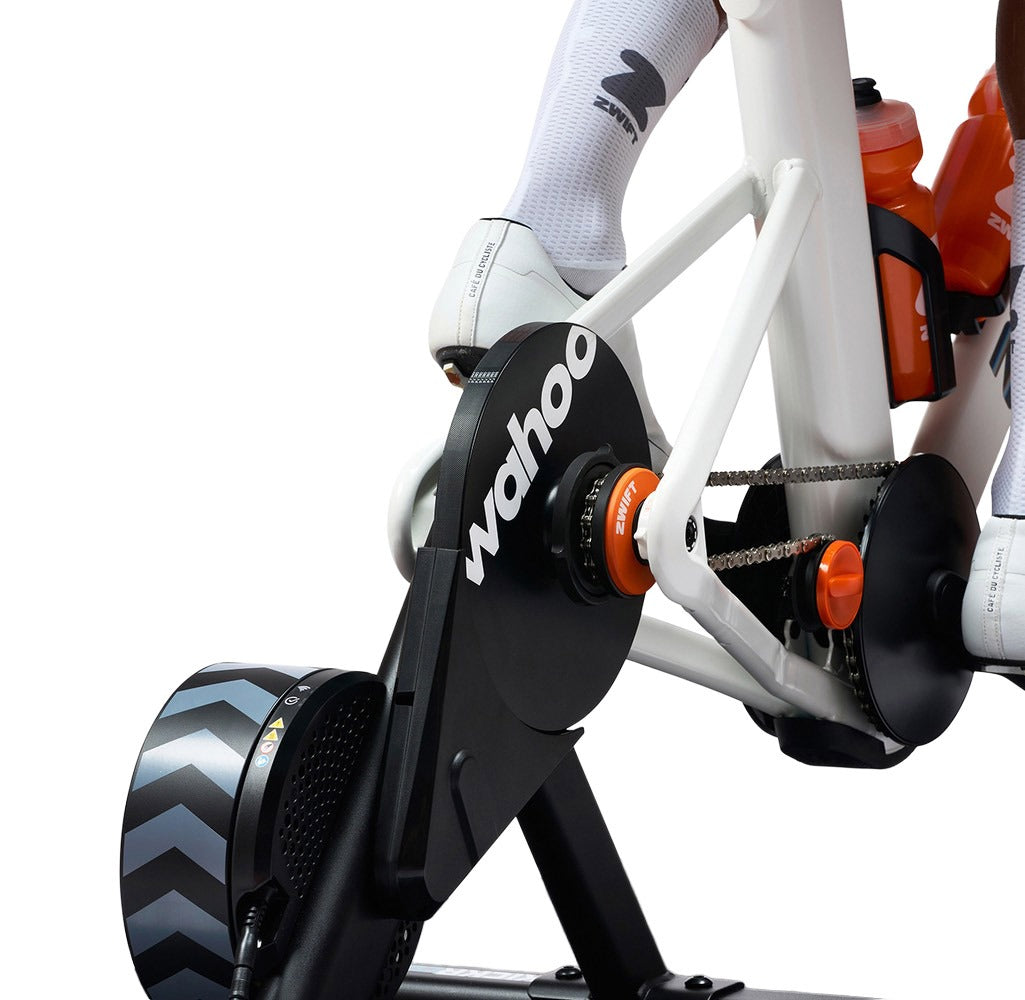 Close-up of a Wahoo fitness bike trainer with a person wearing cycling shoes.