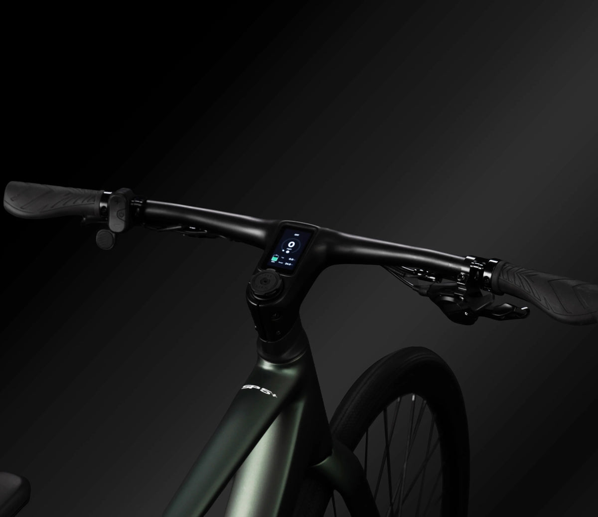 Close-up of a sleek electric bicycle handlebar setup with a small central display, dark textured grips, and a matte dark green frame against a black studio background.