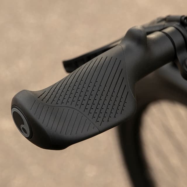 Close-up of a black bicycle handgrip on a beige background