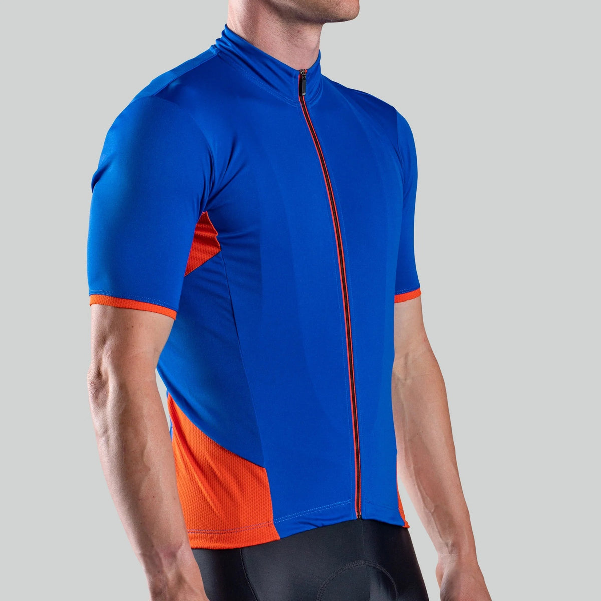 A man wearing a blue and orange cycling jersey on a light grey background
