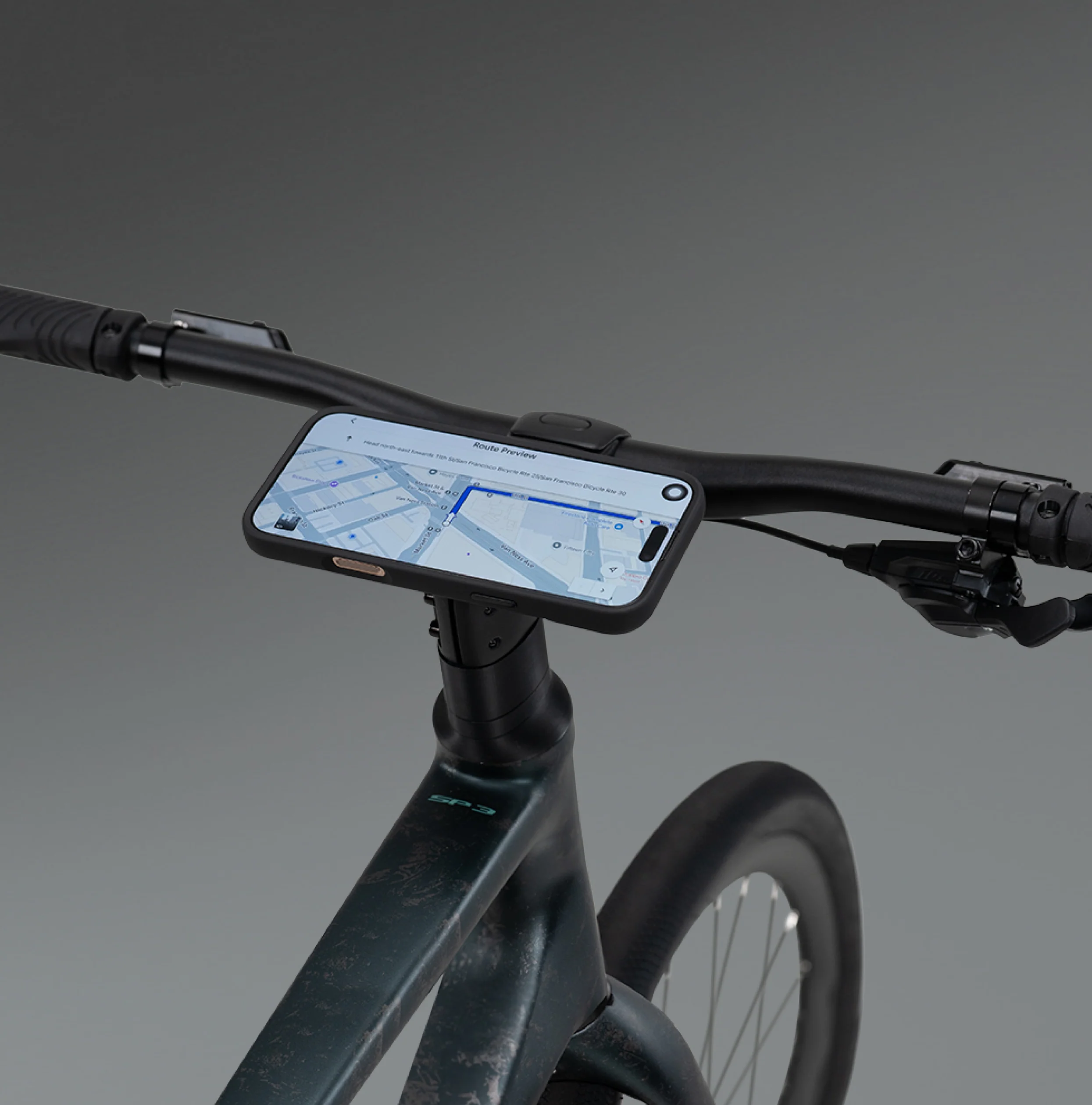 Bicycle handlebar with a smartphone mounted on a holder against a gray background
