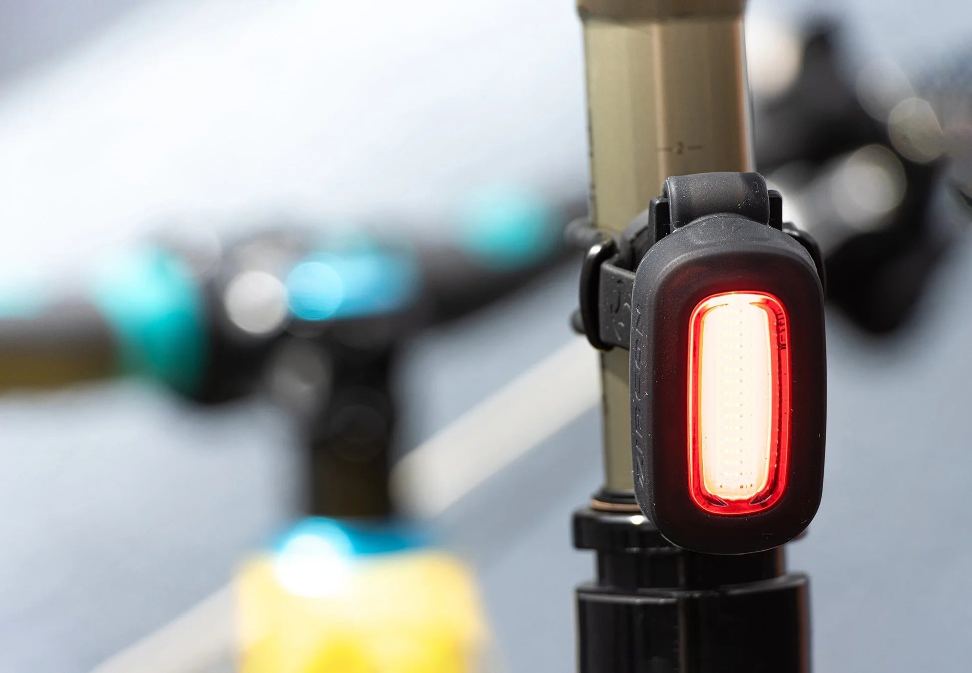 Bicycle tail light attached to a bike frame with a blurred background