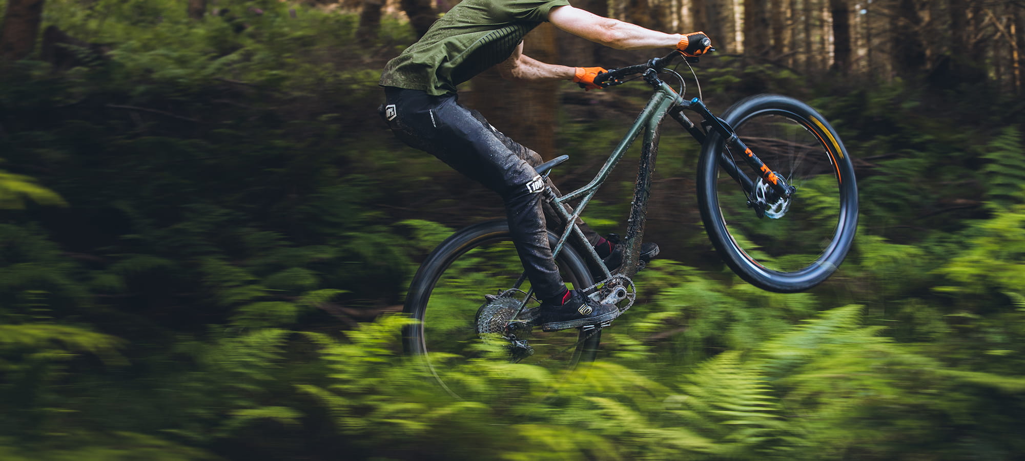 A picture of someone doing a wheelie in the bush on the Orbea Laufey H30 Hardtail Mountain Bike