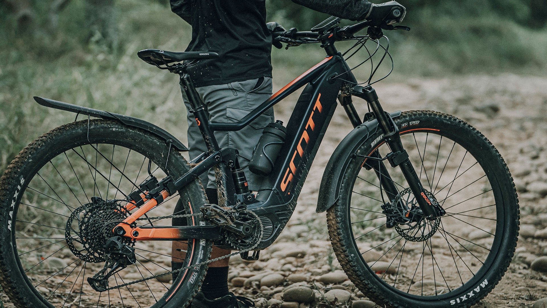 A picture of someone holding a mountain bike with the  Topeak Tetrafender M1 / M2 Set MTB Fork/Stay Mount Mudguards mounted to the bike