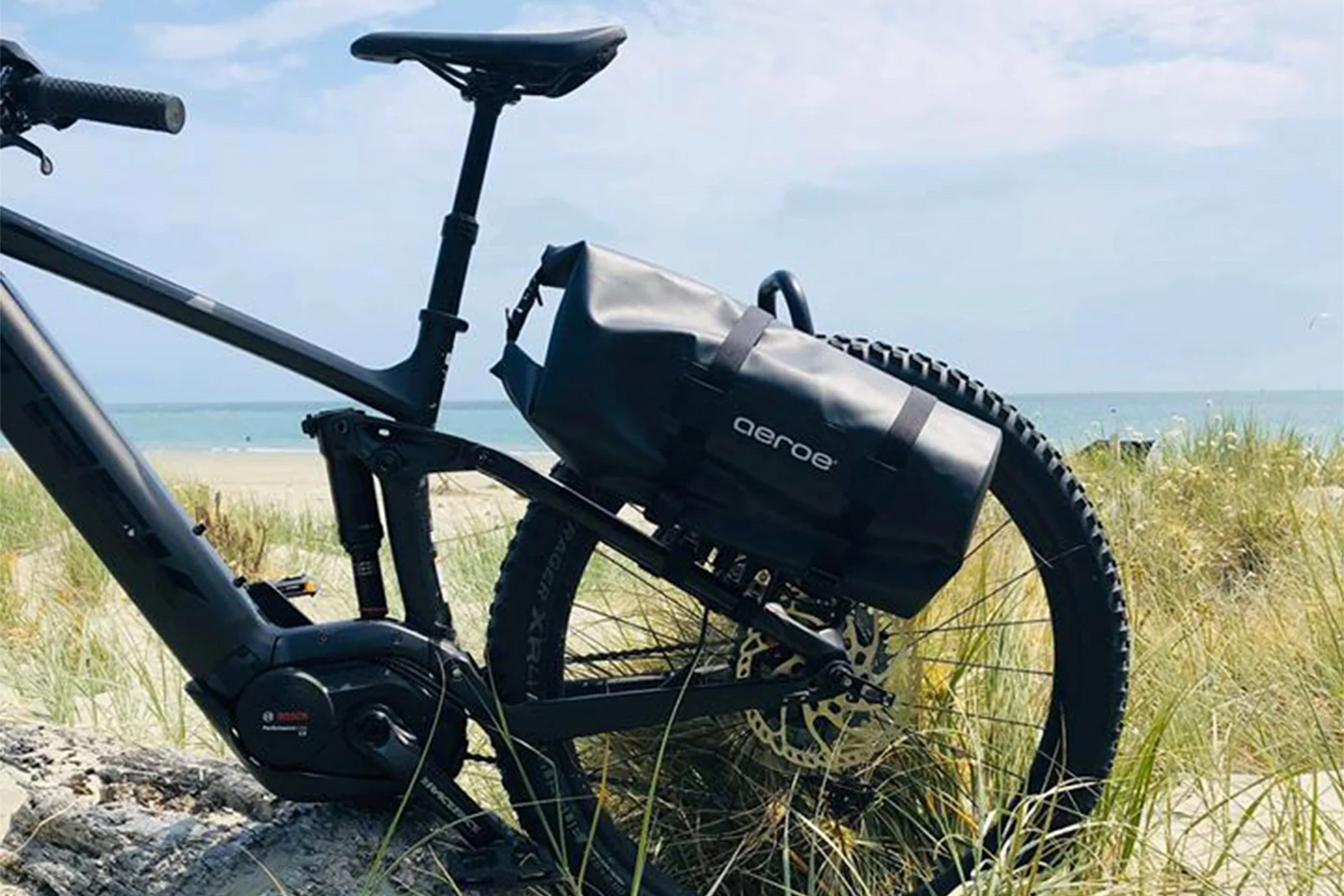 A picture of the Aeroe Spider Rear Cradle for Bike Rack attached to the rear rack on a bike with bags